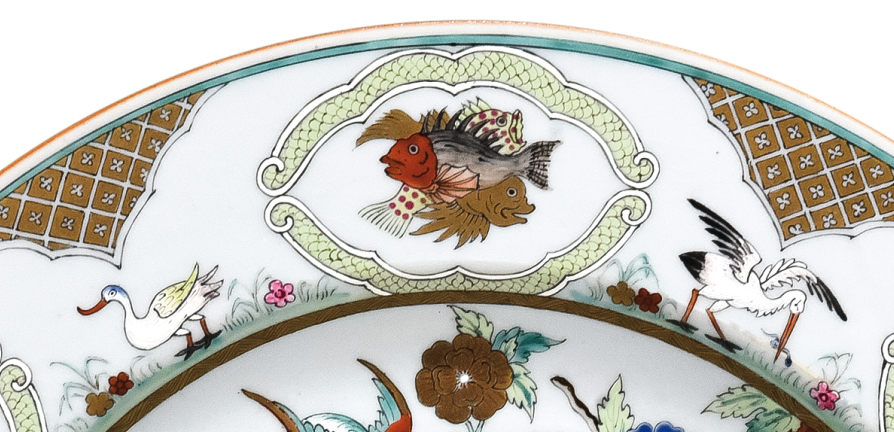 圖為清中期廣彩人物紋大碟細(xì)節(jié)圖，碟沿對稱開六窗繪魚紋，間繪六組鳥禽紋。（來源：廣州十三行博物館）