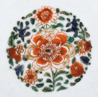 圖為清代五彩花卉紋碟細(xì)節(jié)圖，碟心主題紋飾為團(tuán)花圖，紅花綠葉，相映成趣。（來源：廣州十三行博物館）
