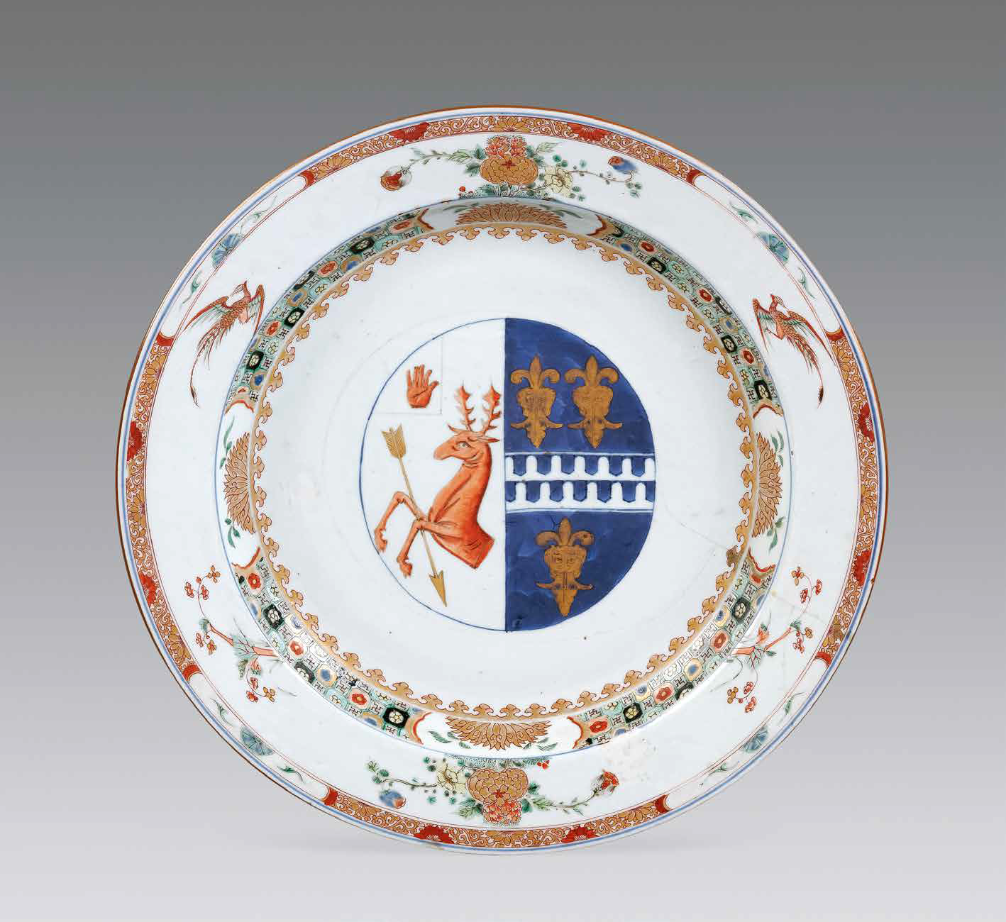 “外銷瓷”是指我國生產(chǎn)的，專門銷往國外的瓷器，清代“一口通商”時期，中國瓷器遠銷歐美，對歐美人民生活影響深遠。這一時期輸出的瓷器種類眾多，有粉彩、廣彩、青花、五彩等，器物造型及紋飾圖案既保留了中國制瓷藝術的傳統(tǒng)特征，又汲取了歐美的藝術精華，從而燒制出了大量精美的瓷器。圖為清康熙Decker家族和Watkins家族聯(lián)姻紋章大盤。外銷瓷中常見兩個家族組合紋章的紋章瓷，這樣的瓷器通常是為家族成員聯(lián)姻而定