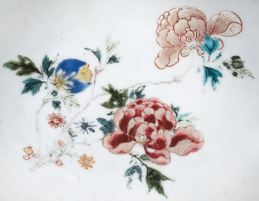 圖為清中期粉彩花卉紋剃須盤(pán)細(xì)節(jié)圖，盤(pán)心主題紋飾為花卉圖。（來(lái)源：廣州十三行博物館）